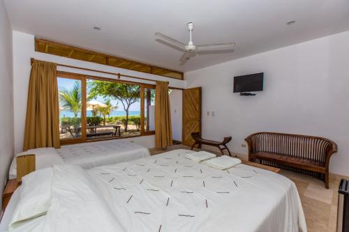 a bedroom with a large bed and a window at Balihai Bungalows in Canoas De Punta Sal