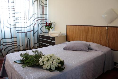 a bedroom with a bed with a bouquet of flowers on it at Hotel Giada in Turin