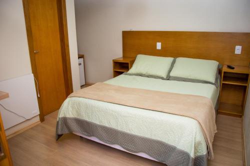 a bed in a room with a wooden floor at Morada Bem Me Quer in Canela