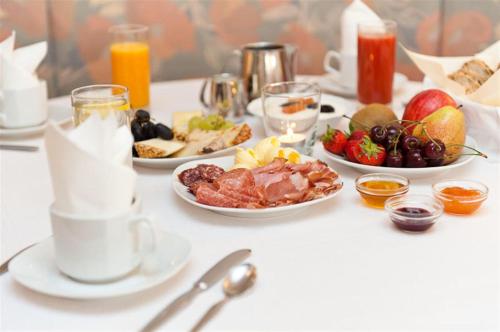 a table topped with plates of food and fruit at Burgus - Design Suites & Apartments in Burgusio