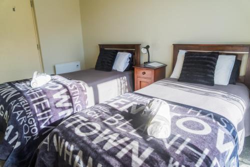 two beds sitting next to each other in a room at Tombstone Motel, Lodge & Backpackers in Picton
