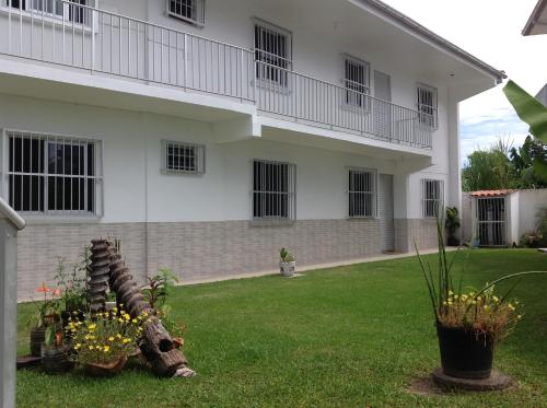 a white house with flowers in the yard at Pousada Mera in Florianópolis