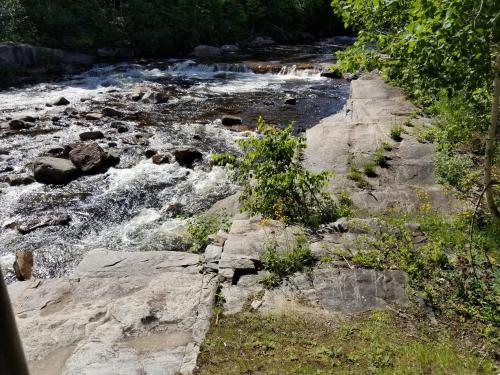 a stream of water with rocks in a river at Motel et Chalets Bo-Fleuve Evangeline in Saint-Siméon