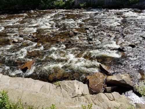 a stream of water with rocks in a river at Motel et Chalets Bo-Fleuve Evangeline in Saint-Siméon