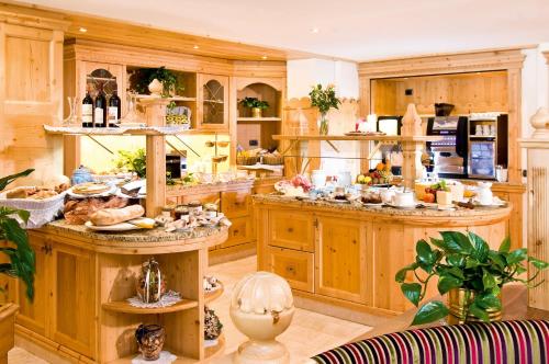 a large kitchen with wooden cabinets and a lot of dishes at Boutique Hotel Diana in Madonna di Campiglio