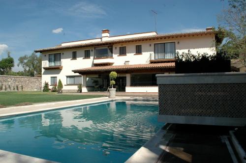 a house with a swimming pool in front of a house at Hotel Regalo del Alma in Tequisquiapan