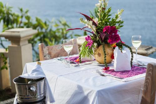 a table topped with a vase filled with flowers at Blue Moon Villas Resort in Amed