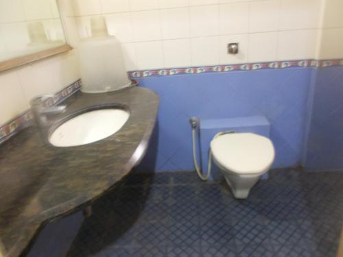 a bathroom with a sink and a toilet at Modern Hotel in Bengaluru