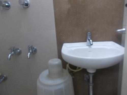 a bathroom with a white sink and a toilet at Modern Hotel in Bengaluru