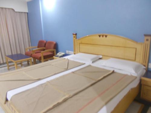 a bedroom with a bed and a table and a chair at Modern Hotel in Bengaluru