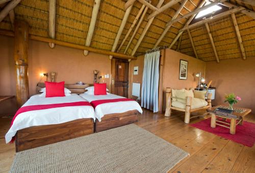 a large bedroom with a large bed and a chair at The Stiltz in Swakopmund