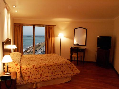 Habitación de hotel con cama y vistas al océano en Hotel Amsterdam en Mar del Plata