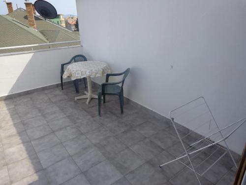a room with a table and chairs on a tile floor at Prometei in Burgas