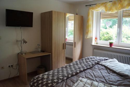 a bedroom with a bed and a flat screen tv at Gästehaus am Steinwald in Friedenfels