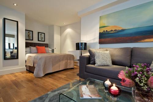 a living room with a couch and a bed at Fraser Residence City in London