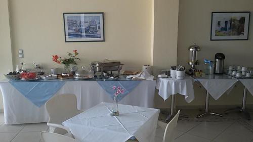 a room with a table and two tables and chairs at Ionion Star Hotel in Tholón