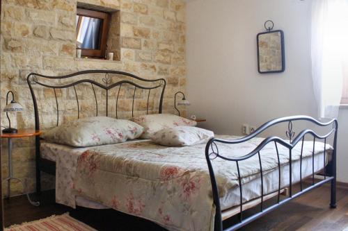 una camera da letto con letto in metallo e cuscini sopra di Mon Perin Castrum - House of Nice Memories a Bale (Valle)