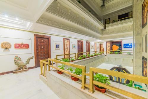 a lobby of a building with potted plants at Hotel Hillock in Mount Ābu