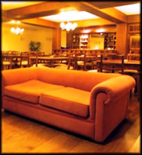 a couch in a room with tables and chairs at Hotel Amsterdam in Mar del Plata