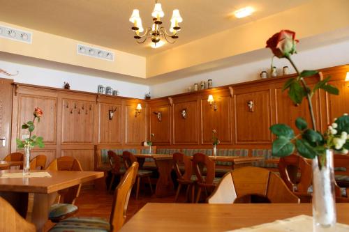a dining room with wooden cabinets and tables and flowers at Elbhotel Bad Schandau in Bad Schandau