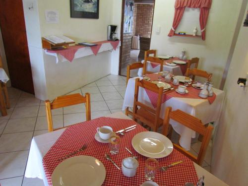 a dining room with a table and chairs and a table and chairsktop at Blue Horizon Bay Guest House in Van Stadensriviermond