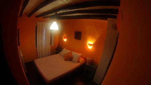 a small room with a small bed and lights at Casa Maza in Asque