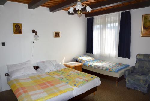 - une chambre avec deux lits et une chaise dans l'établissement Benedekné Háza, à Gyenesdiás