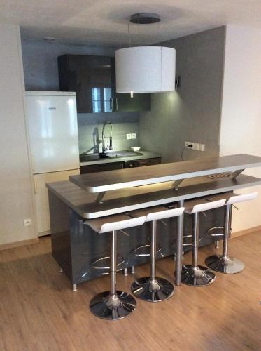 une cuisine avec comptoir et tabourets de bar dans l'établissement montreuil sur mer, à Montreuil-sur-Mer
