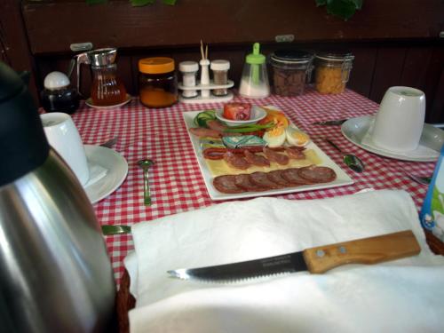 uma mesa com um prato de comida e uma faca em Illés Vendégház em Keszthely