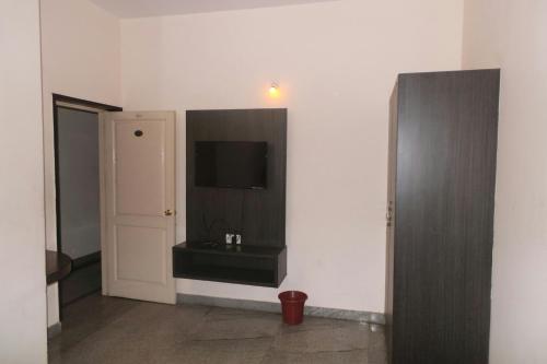 a room with a flat screen tv on a wall at Soundarya Hotel in Bangalore