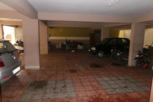 a garage with cars and motorcycles parked in it at Soundarya Hotel in Bengaluru