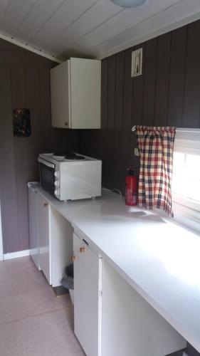 a kitchen with a white counter top with a microwave at Sæteråsen Hytter & Camping Trysil in Trysil