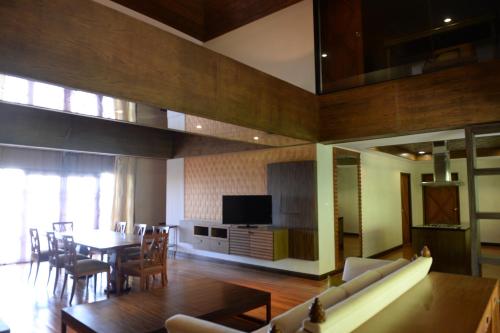 a living room with a dining table and a television at Phuripimarn Penthouse in Pak Chong