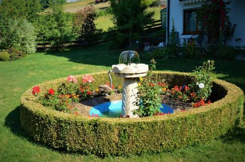 a fire hydrant in a garden with flowers in it at Gästehaus Köglmaier in Kelheim