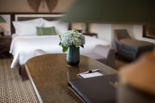 a vase of flowers on a table in a hotel room at Ninh Binh Hidden Charm Hotel & Resort in Ninh Binh