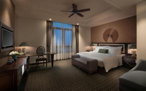 a hotel room with a large bed and a television at Ninh Binh Hidden Charm Hotel & Resort in Ninh Binh