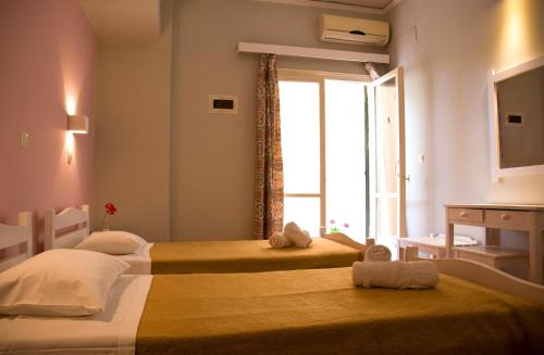 two beds in a room with a window at Evgenios Studios in Kavos