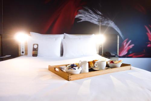 a tray of food sitting on top of a bed at Novotel Amsterdam City in Amsterdam