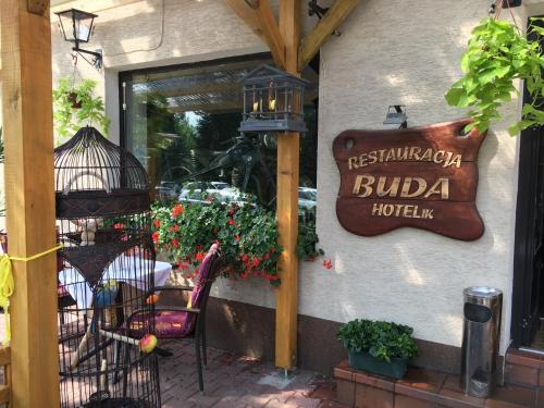 a restaurant with a sign on the side of a building at Restauracja Pensjonat Buda in Krosno