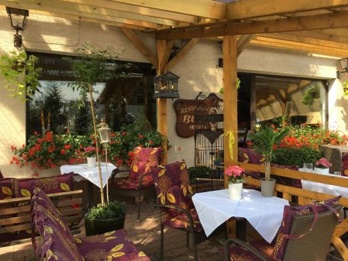 a restaurant with two tables and chairs and flowers at Restauracja Pensjonat Buda in Krosno