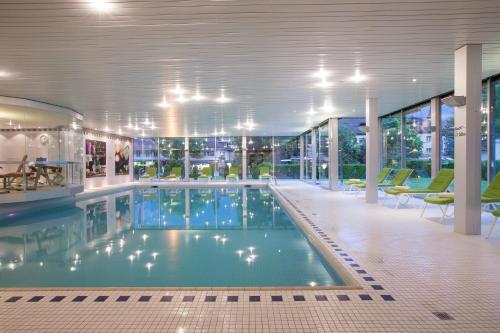 a large swimming pool in a building with windows at Grand Hotel Beau Rivage Interlaken in Interlaken