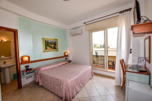 a bedroom with a bed and a window at Hotel Condor in Taormina
