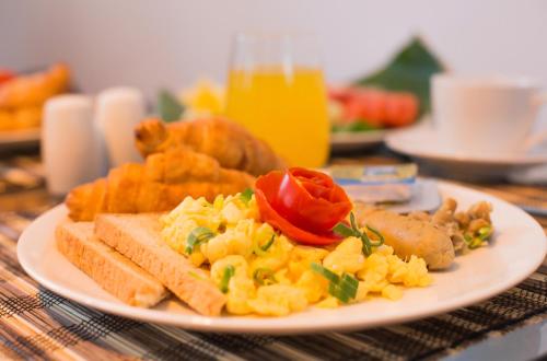 Un plato de desayuno con huevos y tostadas. en Kubu Petitenget Suite Seminyak, en Seminyak