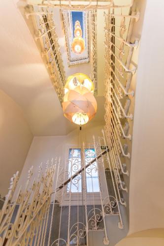 a spiral staircase with a chandelier and a ceiling at Petit Palace Lealtad Plaza in Madrid