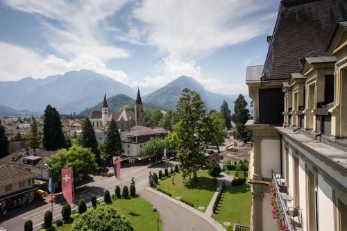a view of a town with mountains in the background at Grand Hotel Beau Rivage Interlaken in Interlaken