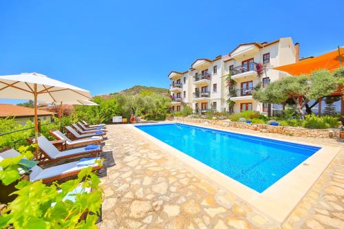 a villa with a swimming pool with chairs and an umbrella at Diva Residence Allsuite Hotel in Kas