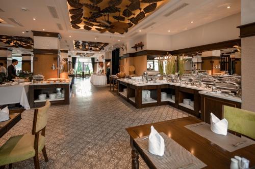 a restaurant with tables and chairs and a bar at Ninh Binh Hidden Charm Hotel & Resort in Ninh Binh