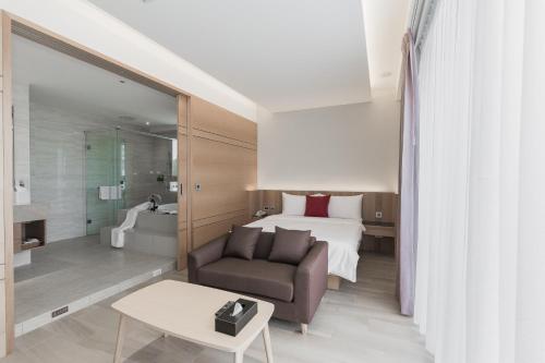 ein Hotelzimmer mit einem Bett, einem Sofa und einem Tisch in der Unterkunft Ai Mei Homestay in Huxi