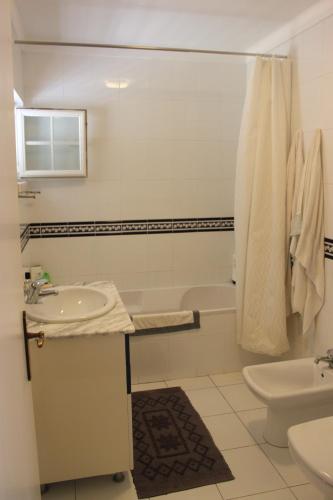 a bathroom with a sink and a toilet and a tub at Casa do Almograve in Almograve