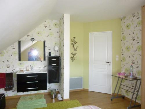 une personne prenant une photo d'une salle de bains avec lavabo dans l'établissement Maison de Charme de La Biette, à Bayenghem-lès-Seninghem